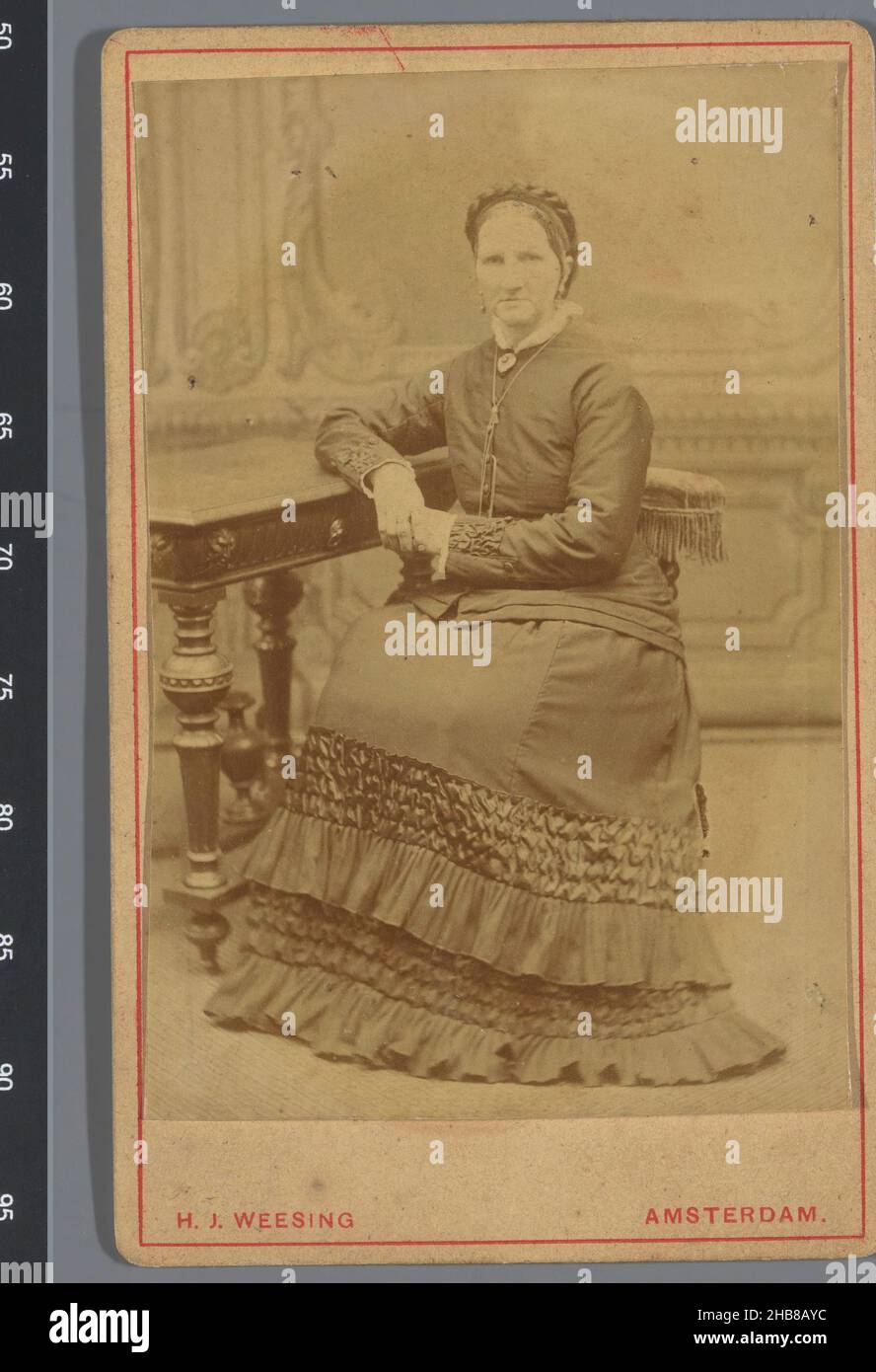 Portrait d'une femme inconnue assise à une table, Hermanus Jodocus Weesing (mentionné sur l'objet), Amsterdam, 1880 - 1900, papier, carton,imprimé albumine, hauteur 104 mm × largeur 65 mm Banque D'Images