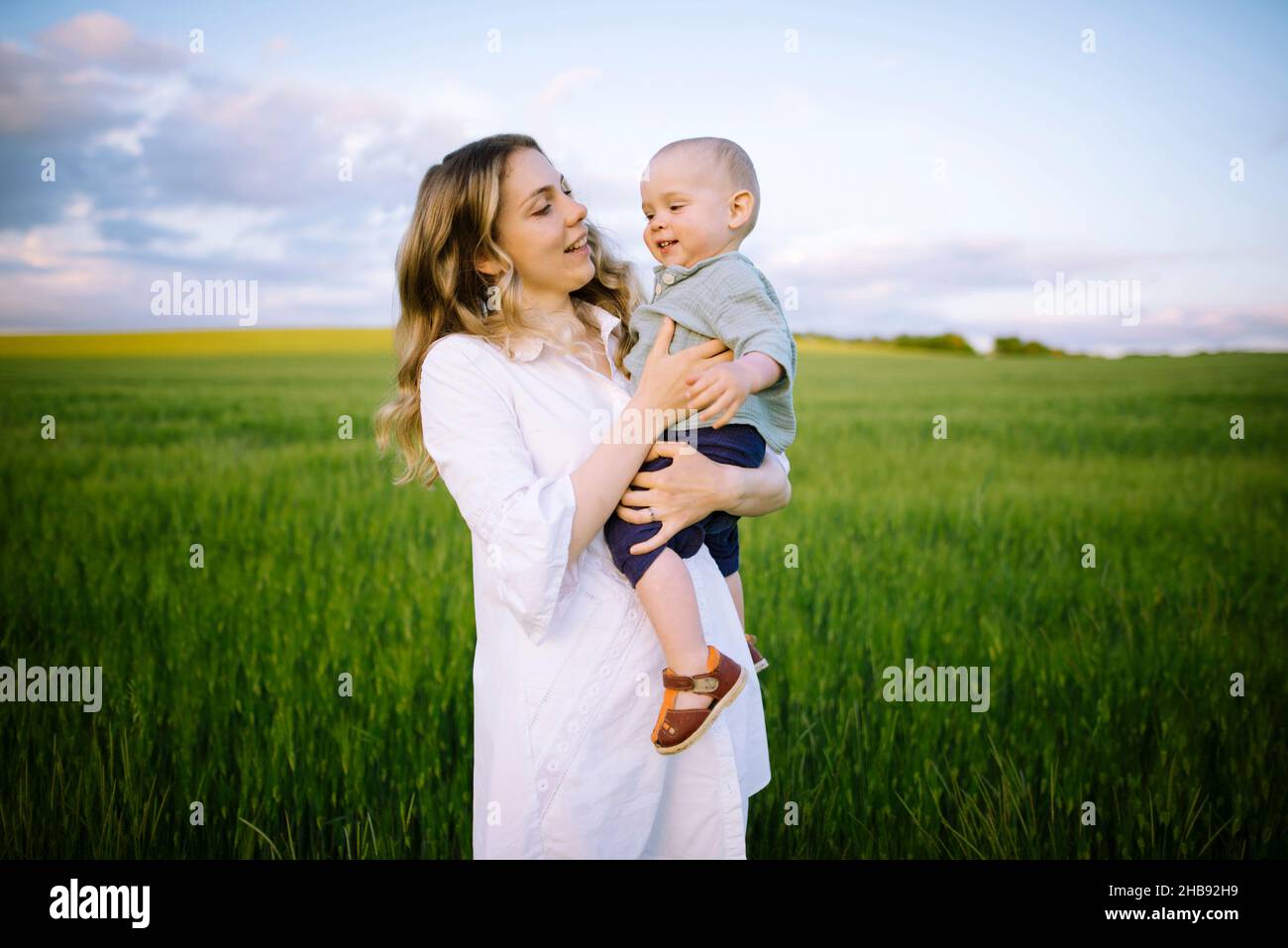 Mère avec bébé fils (12-17 mois) dans le domaine agricole Banque D'Images