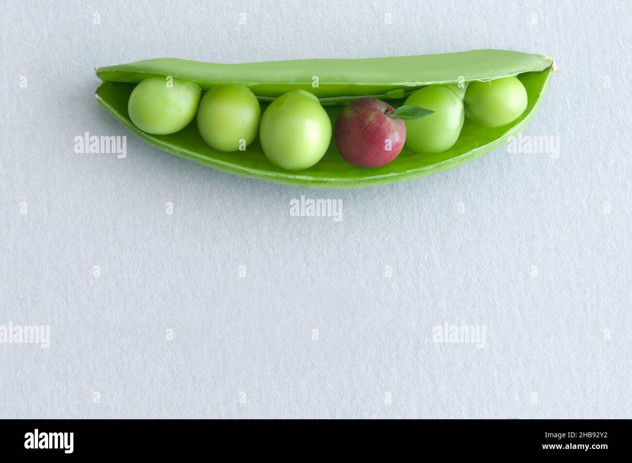 Petits pois dans une gousse avec pomme miniature, concept de régime équilibré Banque D'Images