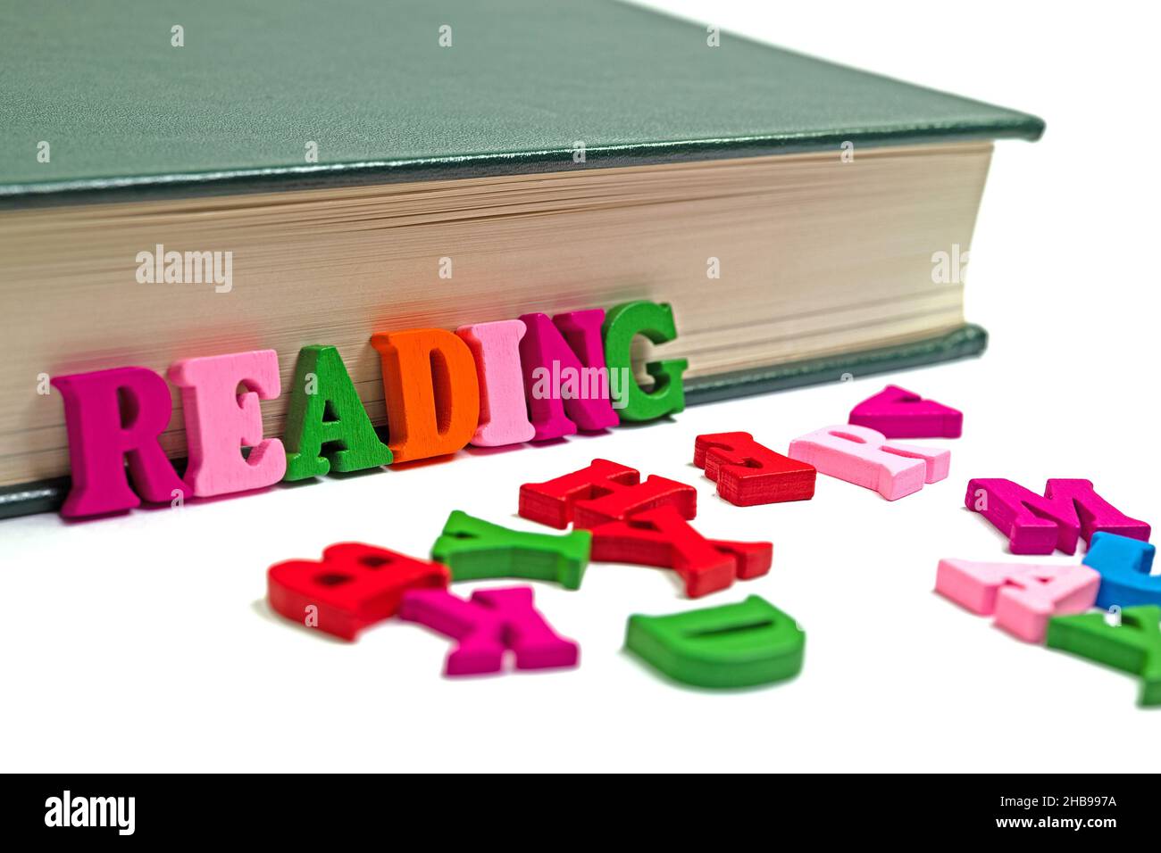 Lettres colorées devant un livre Banque D'Images