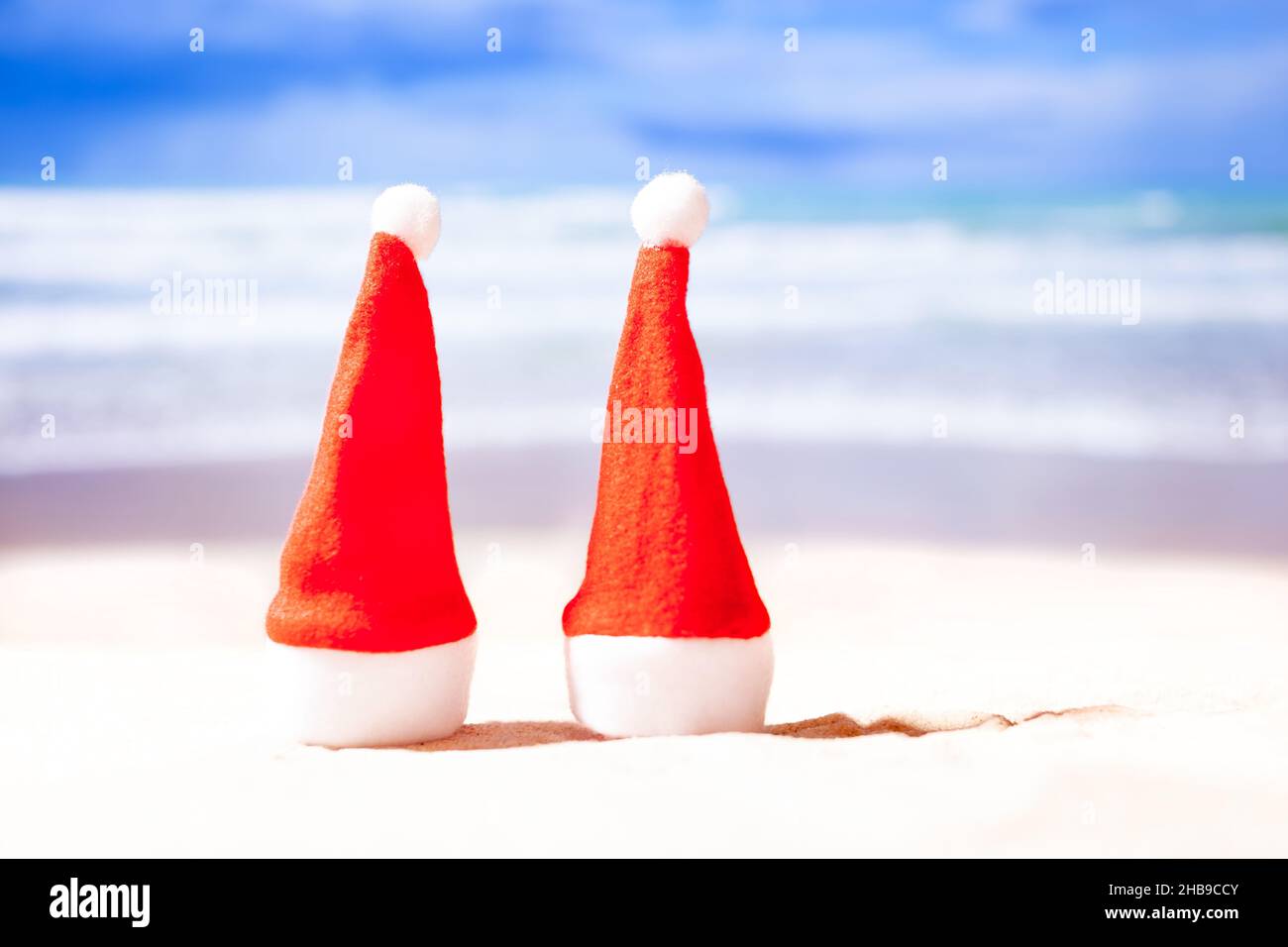 Nouvel an sur la plage.Deux chapeaux de Noël sur la plage sur fond d'océan, espace de copie Banque D'Images