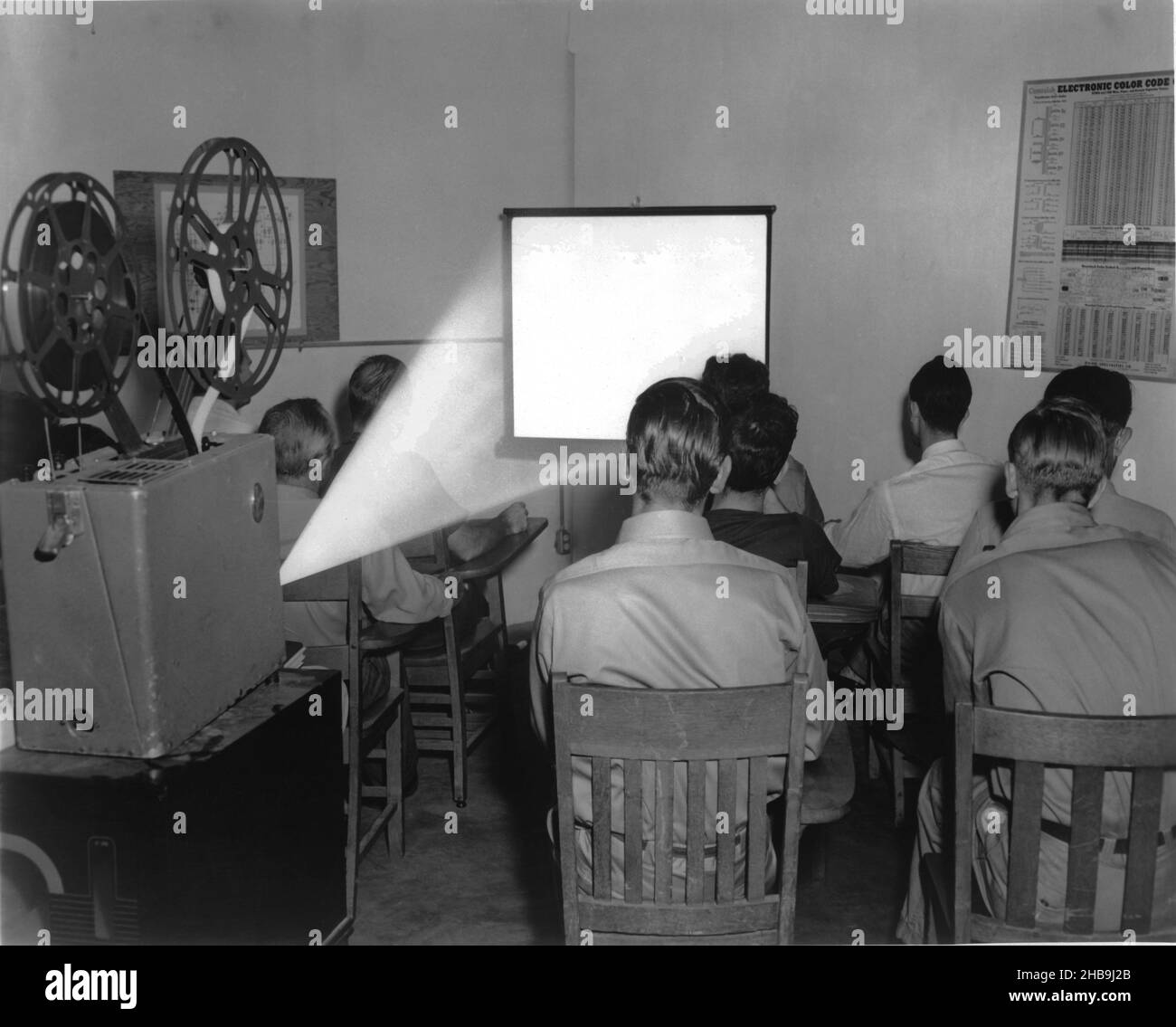 Des hommes de groupe assis en classe regardant un film sur un écran.Vers 1951 Banque D'Images