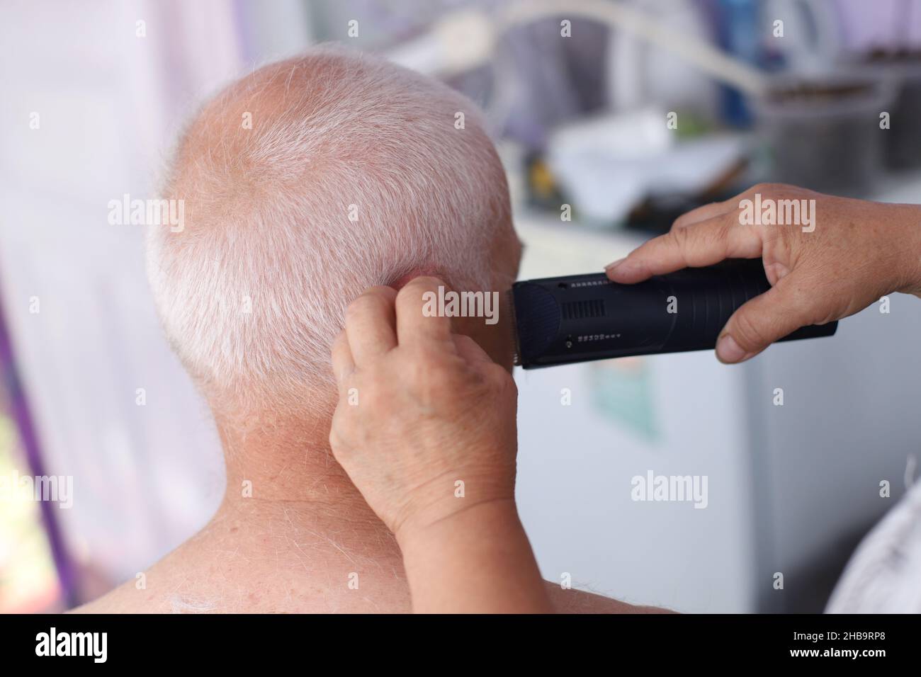 Femme âgée qui obtient une coupe de cheveux à la maison Banque D'Images
