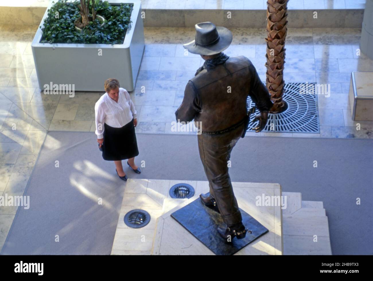 Femme admirant la statue de John Wayne à l'aéroport de Costa Mesa, dans le comté d'Orange, en Californie Banque D'Images