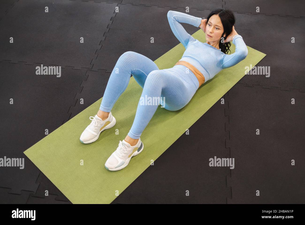 Belle femme faisant de l'abs exercice assis-up dans la salle de gym Banque D'Images