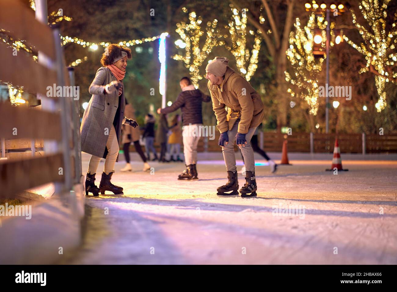 Un jeune couple amoureux a un bon moment en patinant à la patinoire pendant les vacances de noël, lors d'une belle nuit dans la ville.Noël, nouvel an Banque D'Images