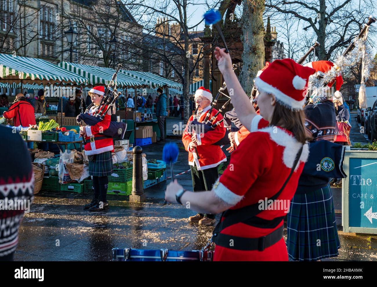 Haddington, East Lothian, Écosse, Royaume-Uni, 18th décembre 2021.Groupe de tubes de Noël : les membres du groupe de tuyaux de Haddington déguisent des costumes de Noël pour jouer au dernier des marchés fermiers mensuels pour cette année à court Street par une froide journée d'hiver ensoleillée Banque D'Images