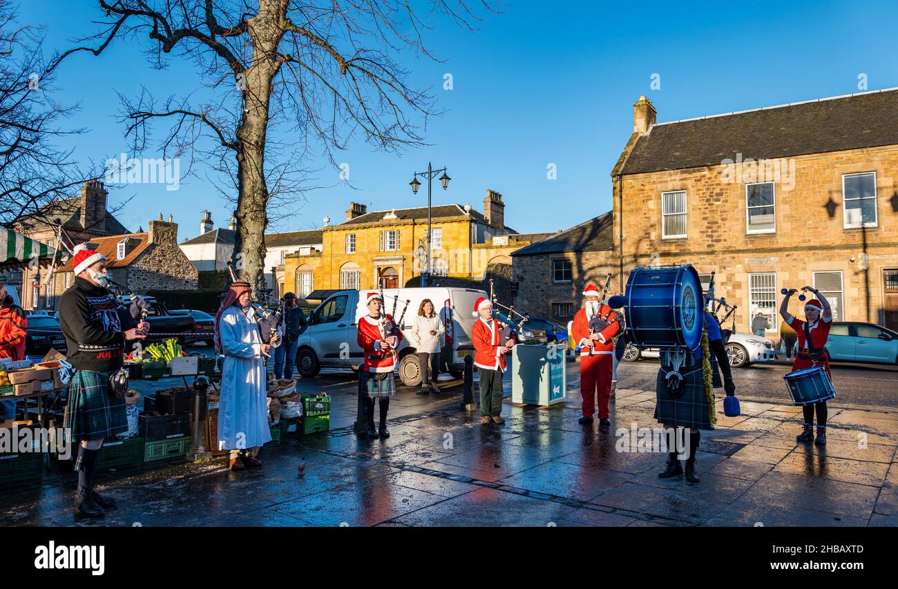 Haddington, East Lothian, Écosse, Royaume-Uni, 18th décembre 2021.Groupe de tubes de Noël : les membres du groupe de tuyaux de Haddington déguisent des costumes de Noël pour jouer au dernier des marchés fermiers mensuels pour cette année à court Street par une froide journée d'hiver ensoleillée Banque D'Images