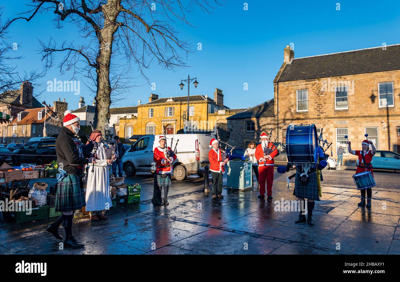 Haddington, East Lothian, Écosse, Royaume-Uni, 18th décembre 2021.Groupe de tubes de Noël : les membres du groupe de tuyaux de Haddington déguisent des costumes de Noël pour jouer au dernier des marchés fermiers mensuels pour cette année à court Street par une froide journée d'hiver ensoleillée Banque D'Images