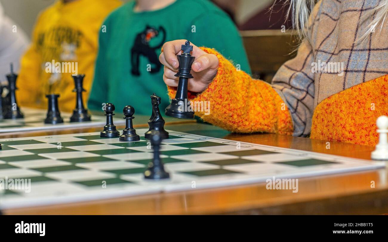 Pièce d'échecs en mouvement de main d'enfant à bord, gros plan Banque D'Images
