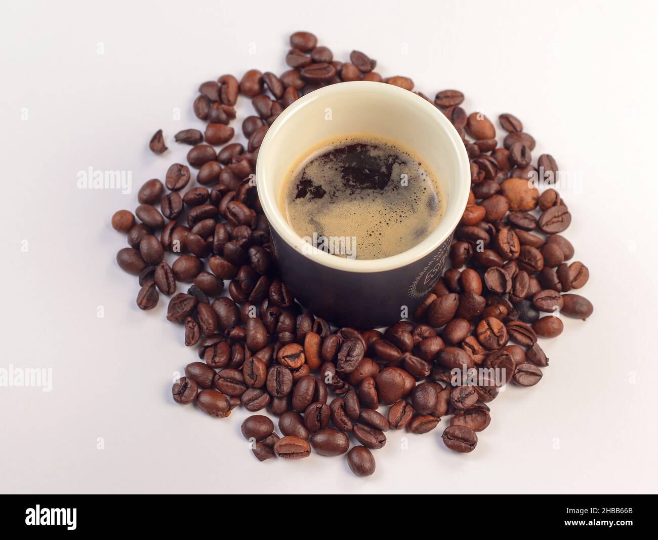 Tasse de café et grains de café.Grain de café sur fond blanc avec une mise au point douce et une lumière excessive sur fond. Banque D'Images