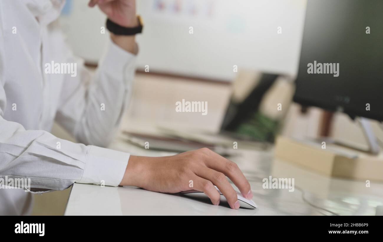 Gros plan de la main du programmateur à l'aide de la souris d'ordinateur, du concept d'ordinateur, de l'ordinateur sur le bureau du programmateur. Banque D'Images