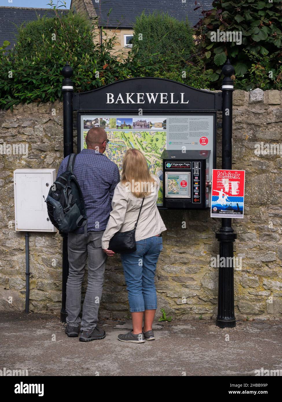 Couple regardant la carte touristique et panneau d'information, Bakewell, Derbyshire Banque D'Images