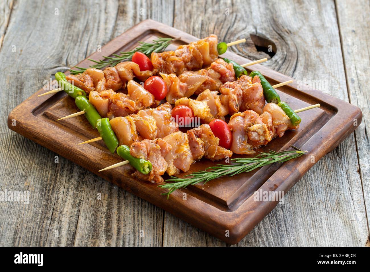 Brochettes de poulet sur fond en bois.Gros plan de brochettes de poulet crues marinées dans la sauce tomate.Vue horizontale Banque D'Images