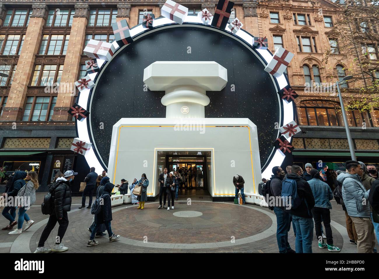 Londres, Royaume-Uni.18 décembre 2021.Les gens à l'extérieur des décorations de Noël de Chanel au magasin phare de Harrods à Knightsbridge.Dans un mouvement inhabituel, au lieu du lendemain de Noël, l'entreprise a commencé sa vente tôt pour essayer de stimuler ses affaires en raison de la réduction de la fréquentation due à la pandémie de coronavirus en cours, maintenant exacerbée par la variante d'Omicron.Credit: Stephen Chung / Alamy Live News Banque D'Images