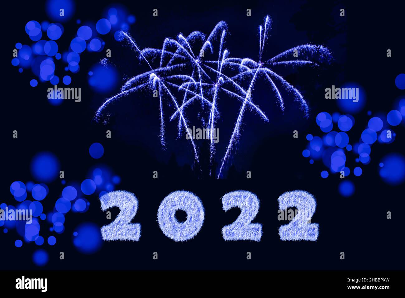 Bonne année 2022.Étincelant brûlante numéros année 2022 avec feu d'artifice et bokeh sur fond noir. Banque D'Images