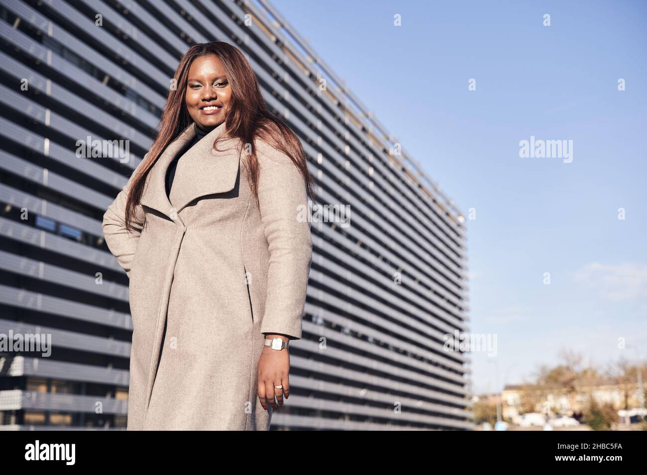 Une femme d'affaires afro-américaine se tient devant le bâtiment de l'entreprise. Banque D'Images