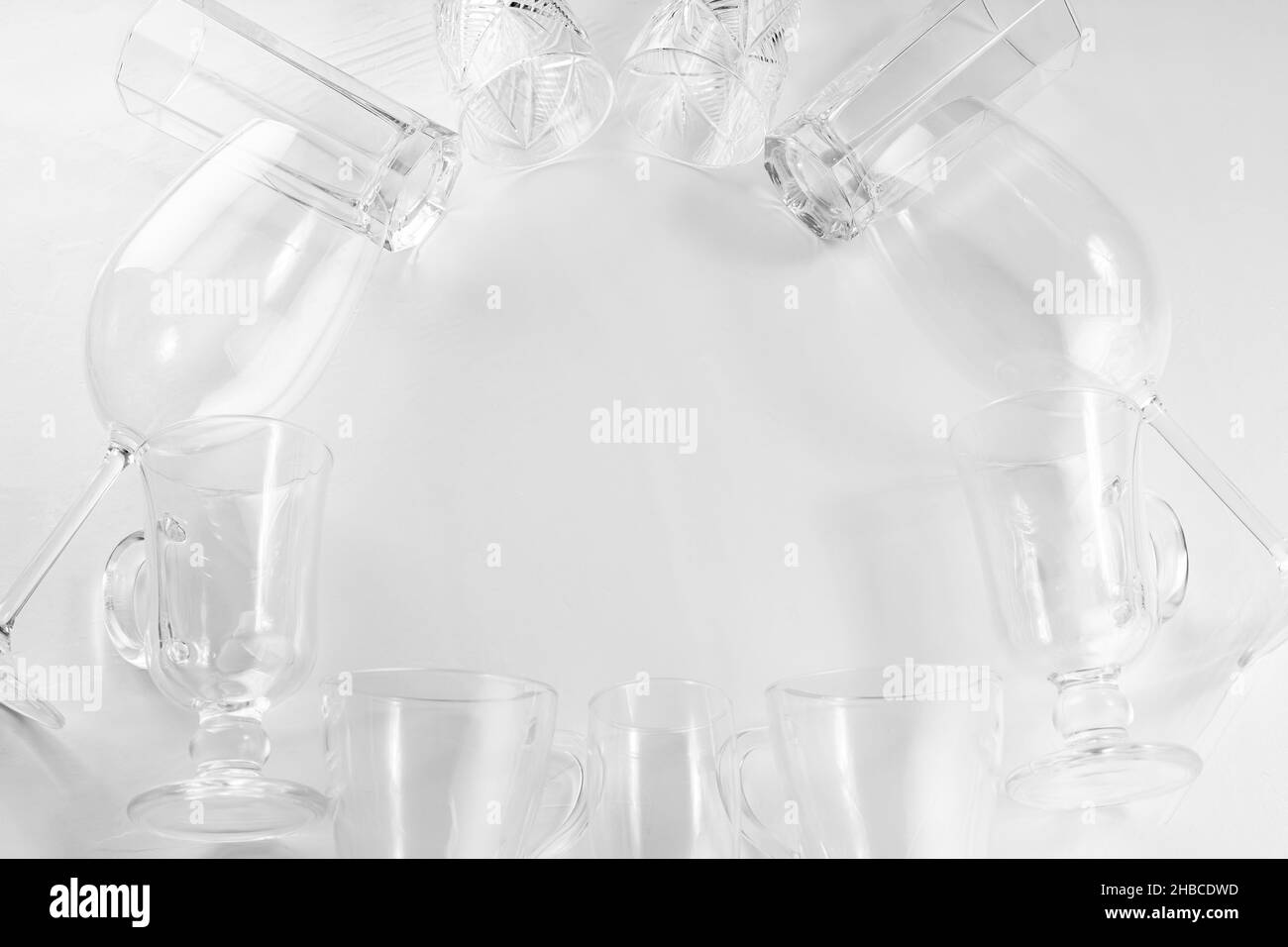 Verres à boisson vides assortis sur fond blanc.Jeu de verres vides sur table blanche.Copier l'espace.Pose à plat Banque D'Images