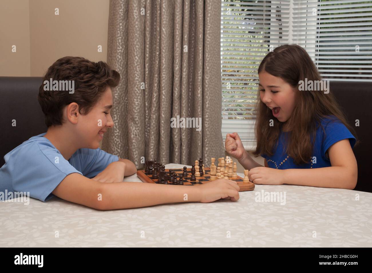 Un frère et une sœur jouant ensemble une partie d'échecs Banque D'Images