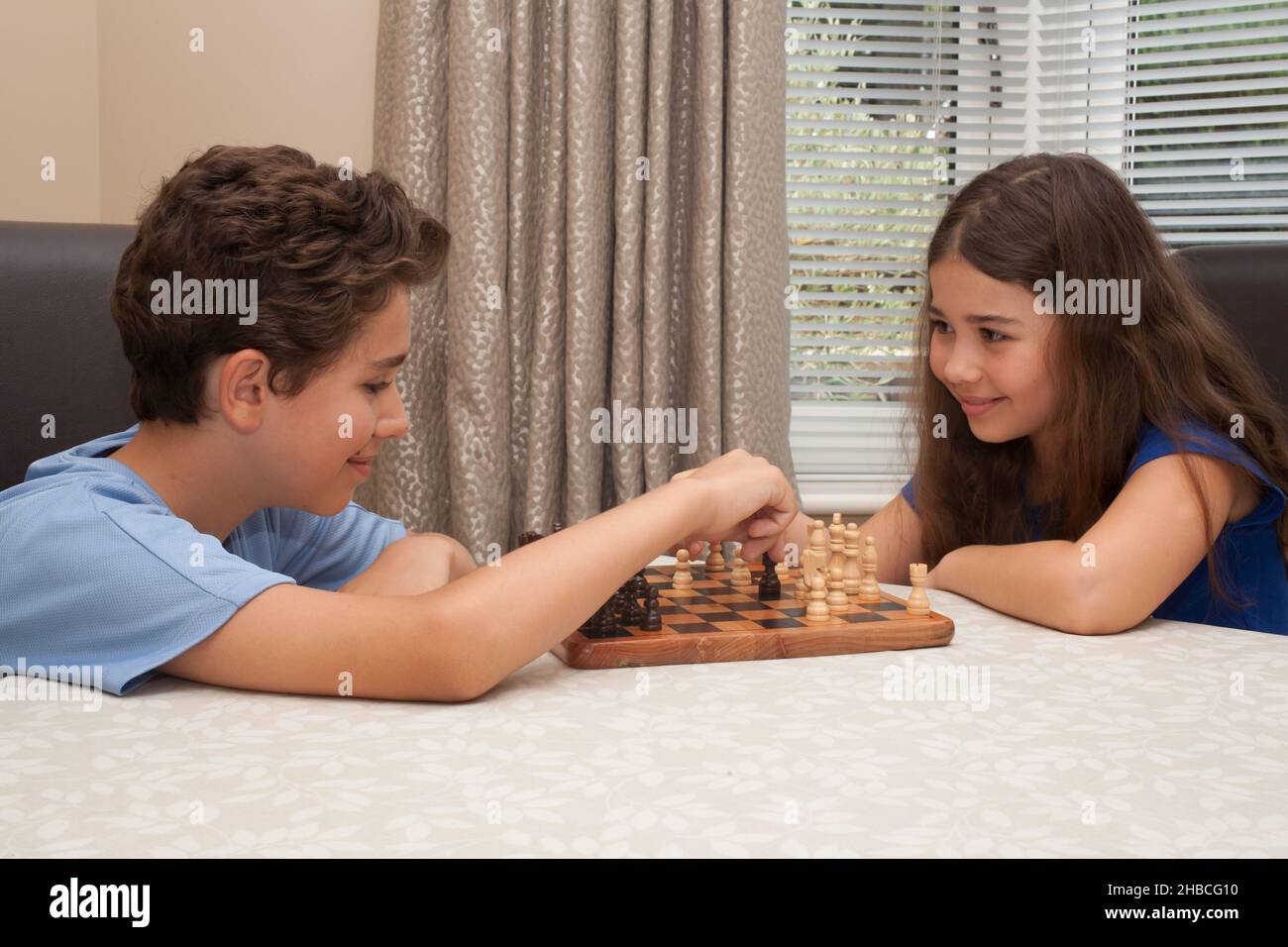 Un frère et une sœur jouant ensemble des échecs, pris le 13 août 2020 à Wool, Dorset, Royaume-Uni Banque D'Images