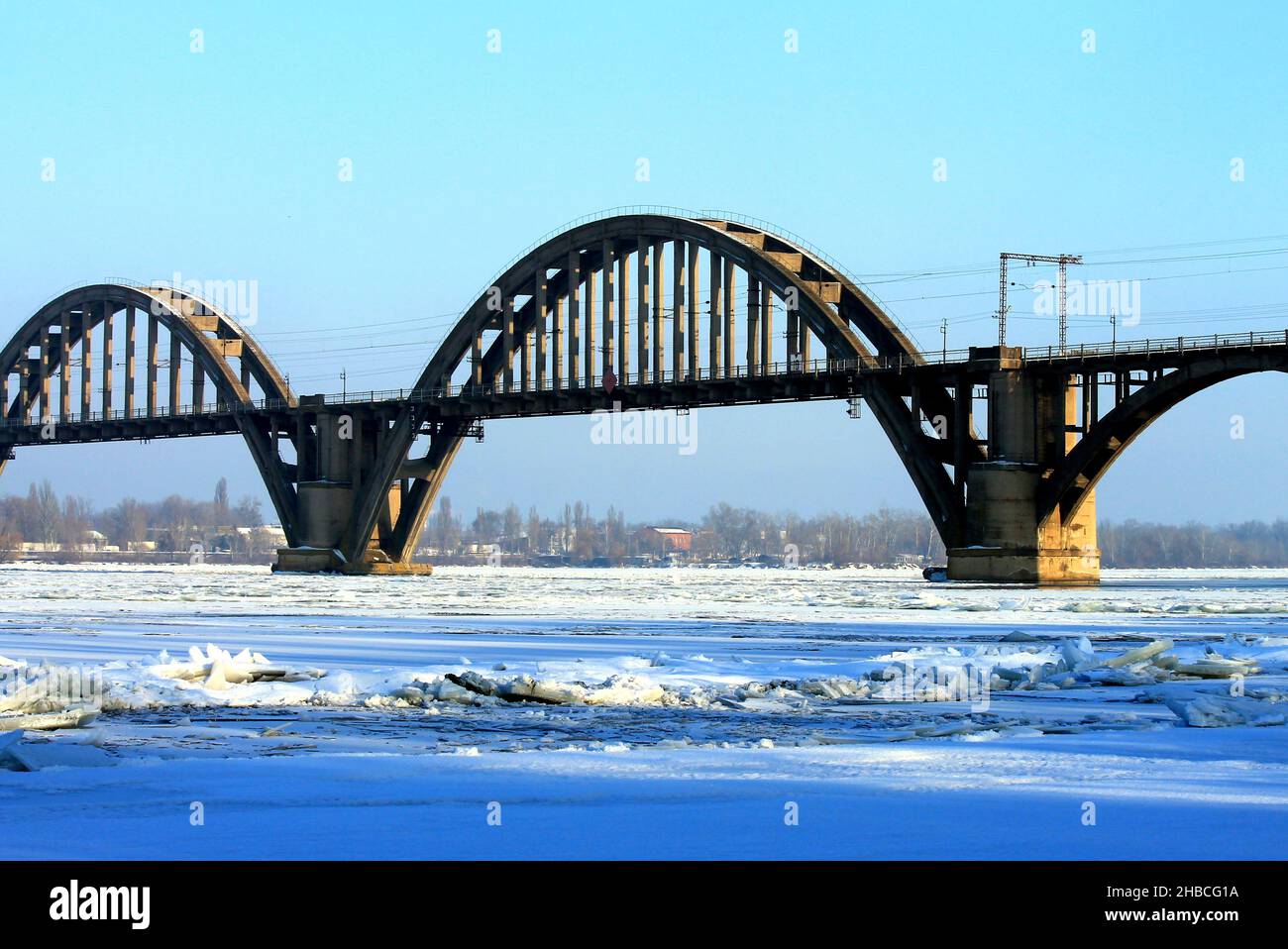 Pont de chemin de fer voûté sur la rivière en hiver.Un beau vieux pont, la rivière Dnieper est couverte de glace et de neige.Dnipro ville, Dnepropetrovsk Banque D'Images