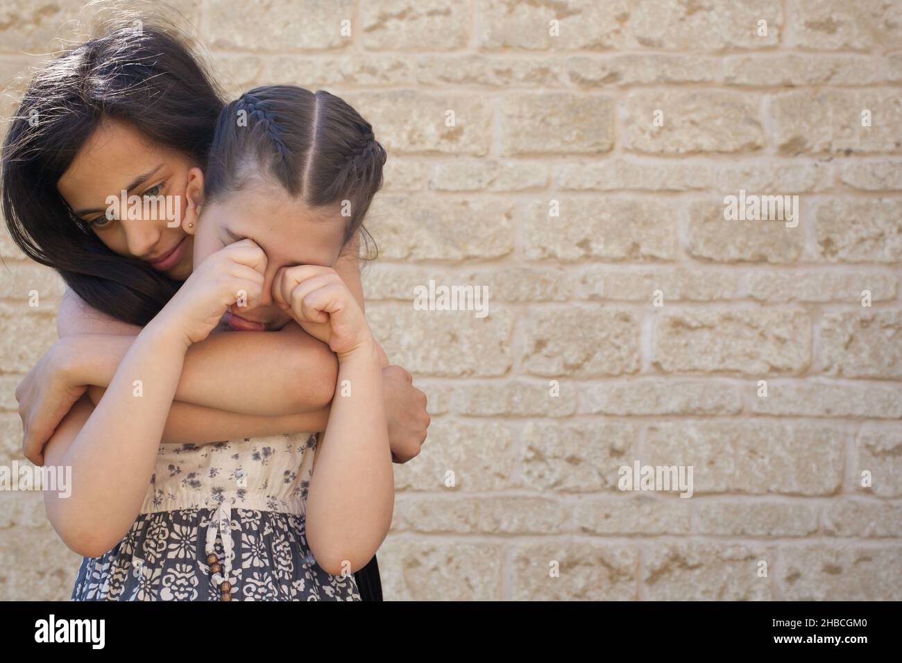Une fille plus âgée soutient une jeune fille qui pleure Banque D'Images
