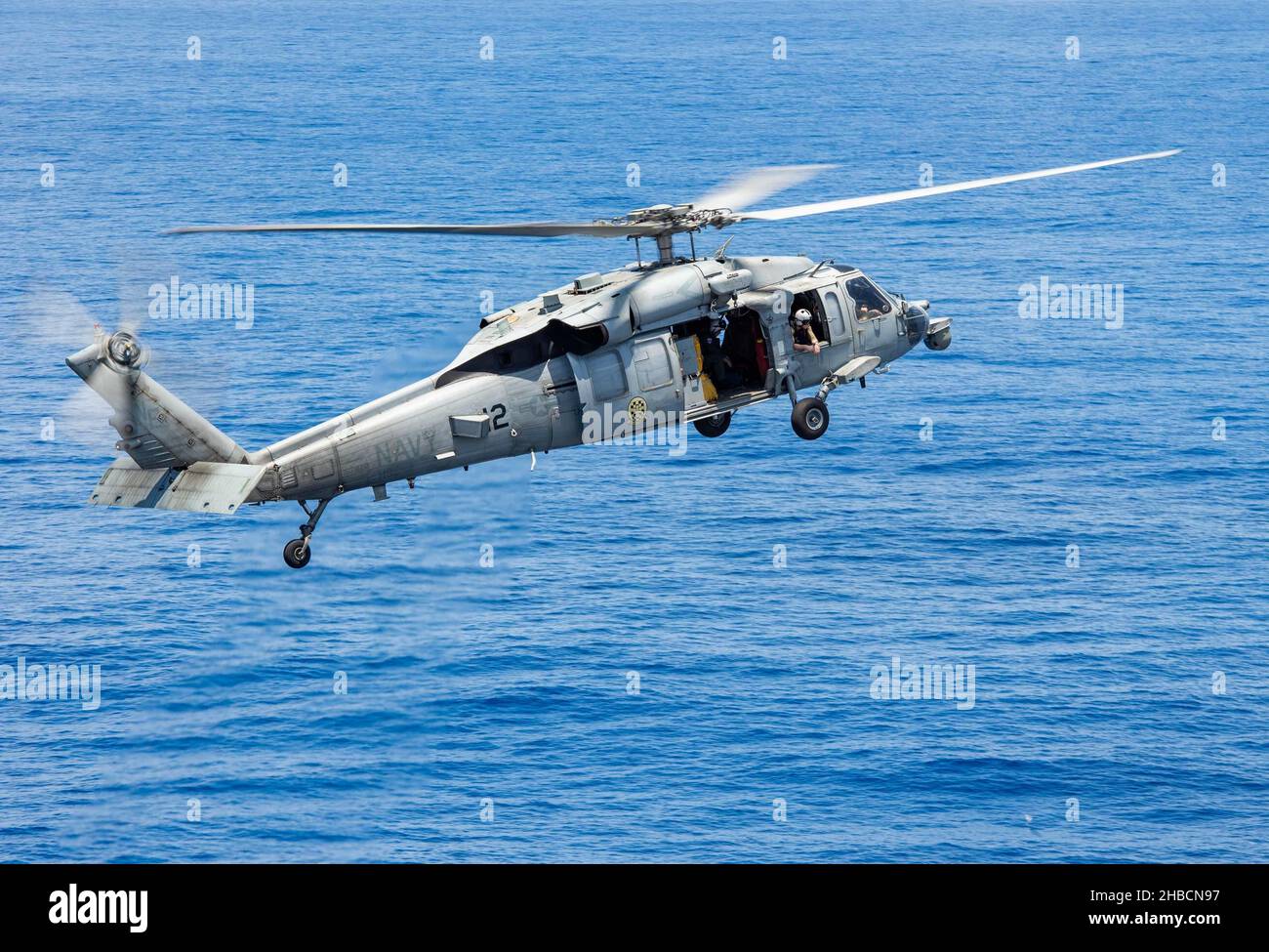 211217-N-RU001-1198 OCÉAN INDIEN (DÉC17, 2021) un hélicoptère MH-60s Sea Hawk, affecté aux « Chevaliers noirs » de l'Escadron de combat de la mer (HSC) 4, se prépare à atterrir sur le pont de vol du porte-avions USS Carl Vinson de la classe Nimitz (CVN 70), le 17 décembre 2021.Carl Vinson Carrier Strike Group est en cours de déploiement prévu dans la zone d'exploitation de la flotte américaine 7th afin d'améliorer l'interopérabilité par le biais d'alliances et de partenariats tout en servant de force de réaction dans une région Indo-Pacifique libre et ouverte.(É.-U.Photo de la marine par le spécialiste en communication de masse apprenti Micheal Mensah) Banque D'Images