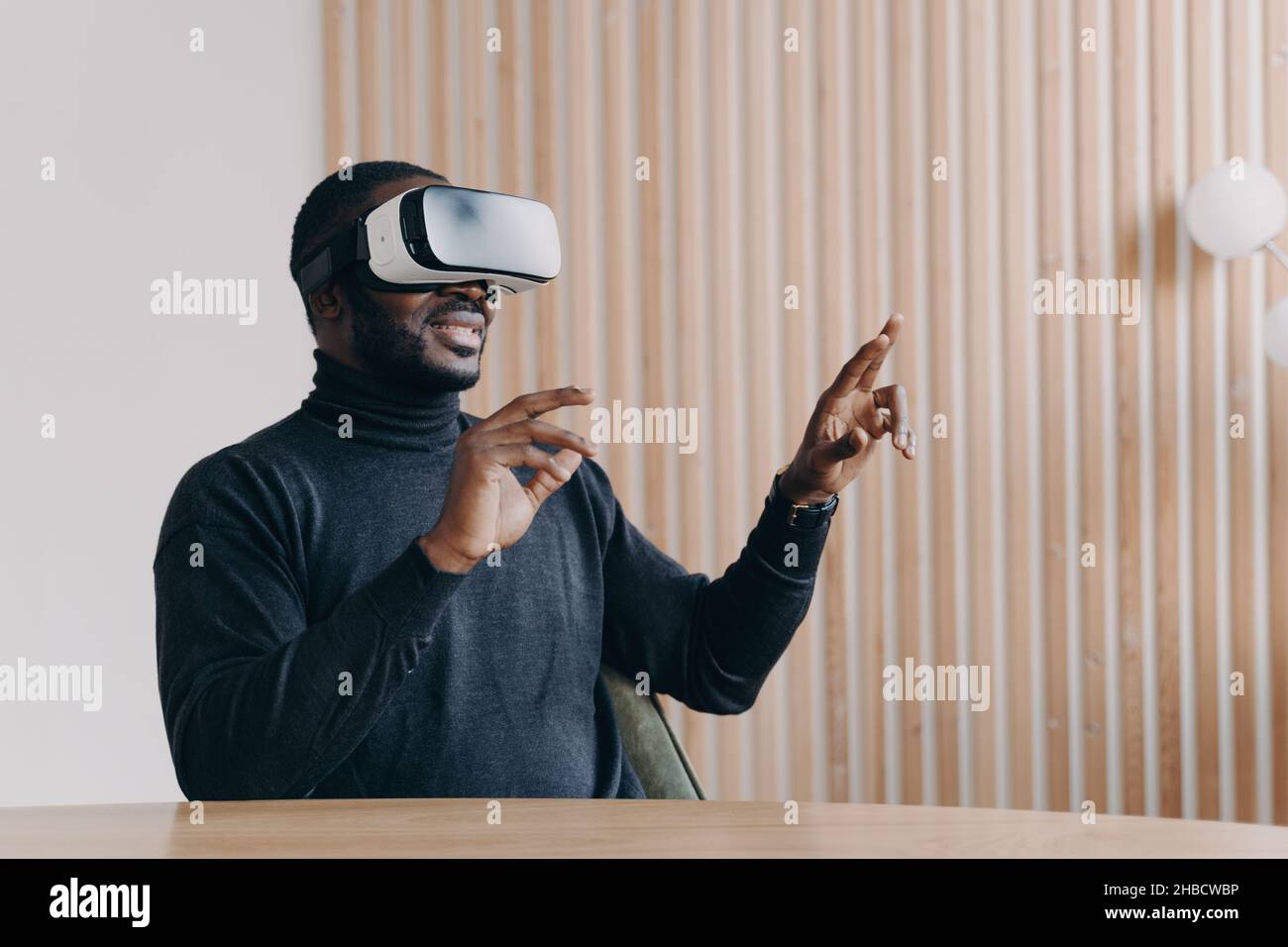 Jeune homme africain joyeux employé de bureau dans VR casque lunettes jouant le jeu favori 3D Banque D'Images