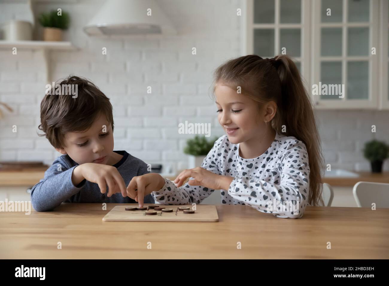 Petit garçon et fille jouant en bois jeu éducatif, dames Banque D'Images