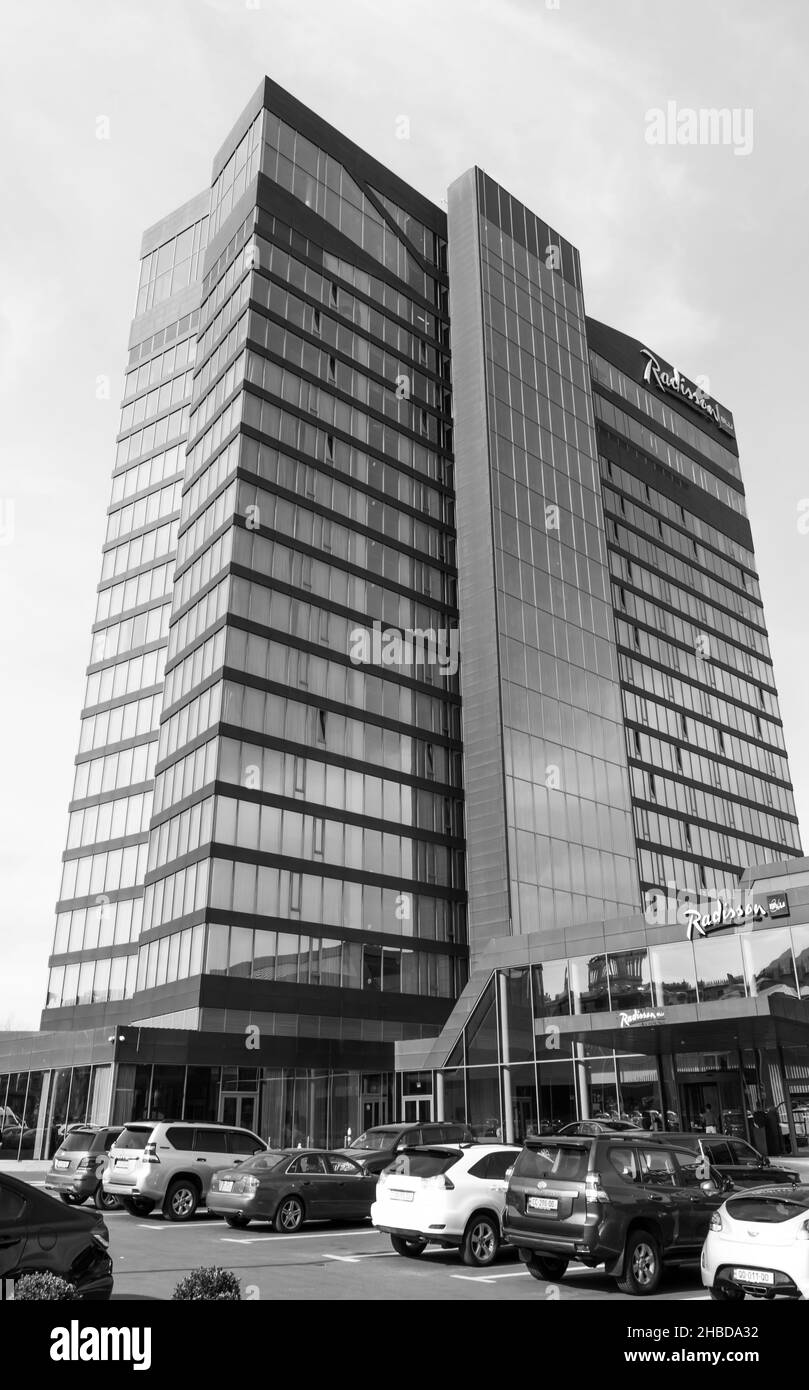 Image en noir et blanc du parking de l'hôtel Radisson blu iveria avec voitures et bâtiment de l'hôtel et entrée avec touriste en arrière-plan.05.04.2020. Banque D'Images