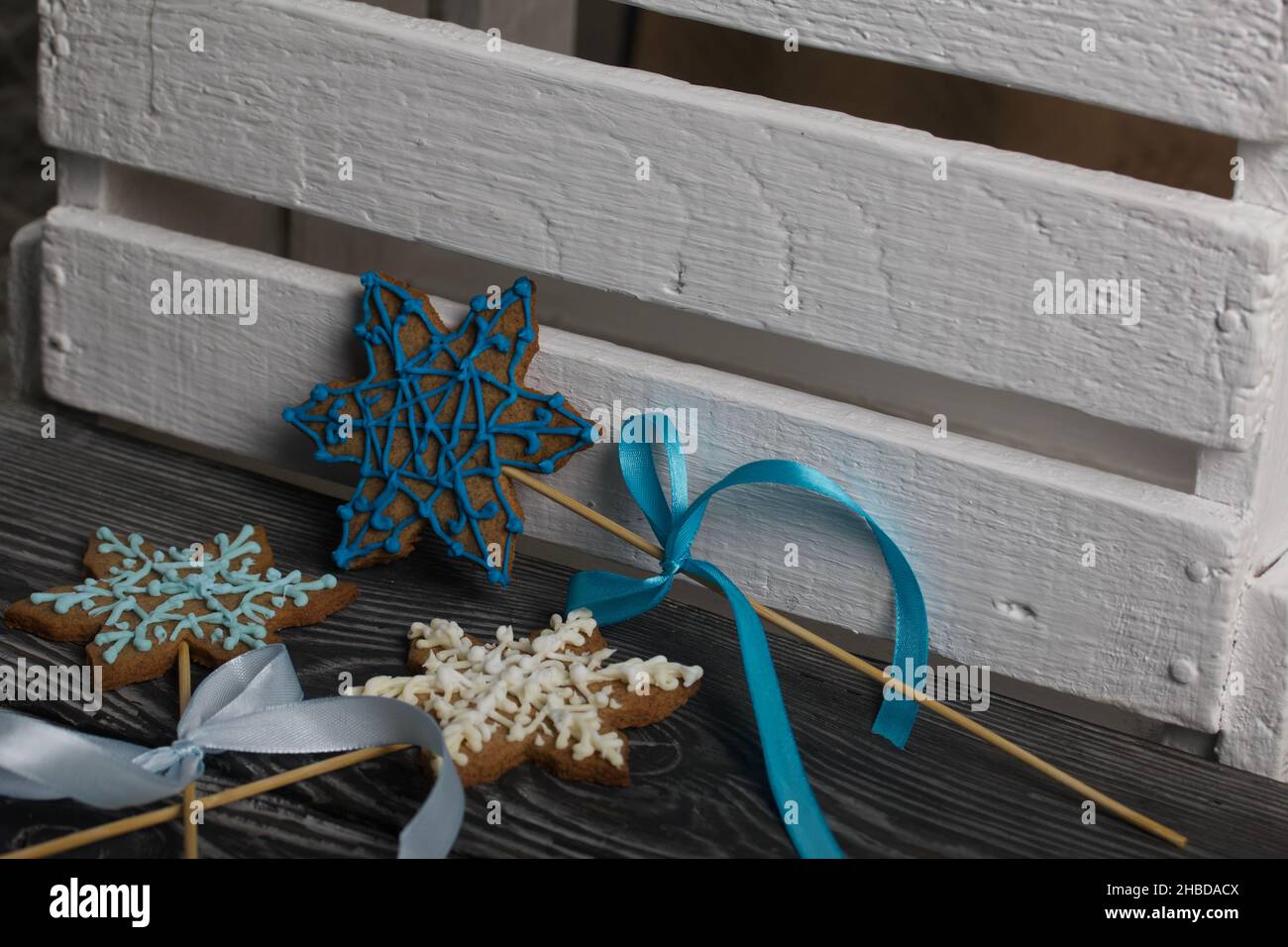Biscuits au pain d'épice en forme de flocons de neige.Décoration avec glaçage au sucre.Biscuits au pain d'épice sur un bâton en forme de flocon de neige.Couchez-vous sur le noir Banque D'Images