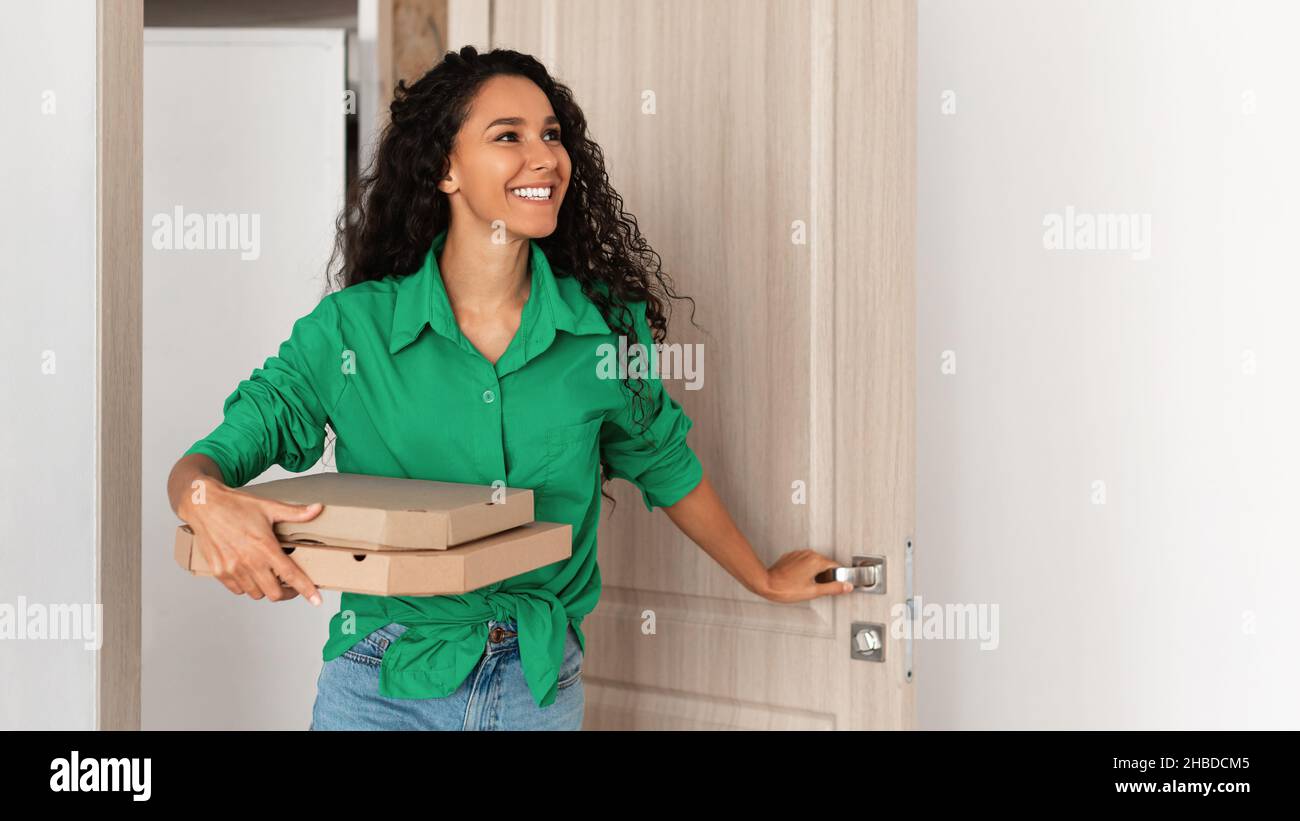 Portrait d'une femme marchant dans un appartement avec des boîtes à pizza Banque D'Images