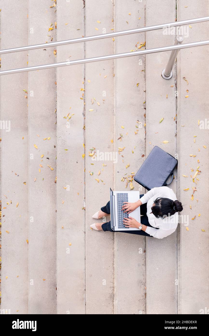 vue de dessus d'une femme d'affaires non reconnaissable travaillant avec son ordinateur portable assis sur un escalier en béton, concept de l'entrepreneur numérique et de l'ourba Banque D'Images