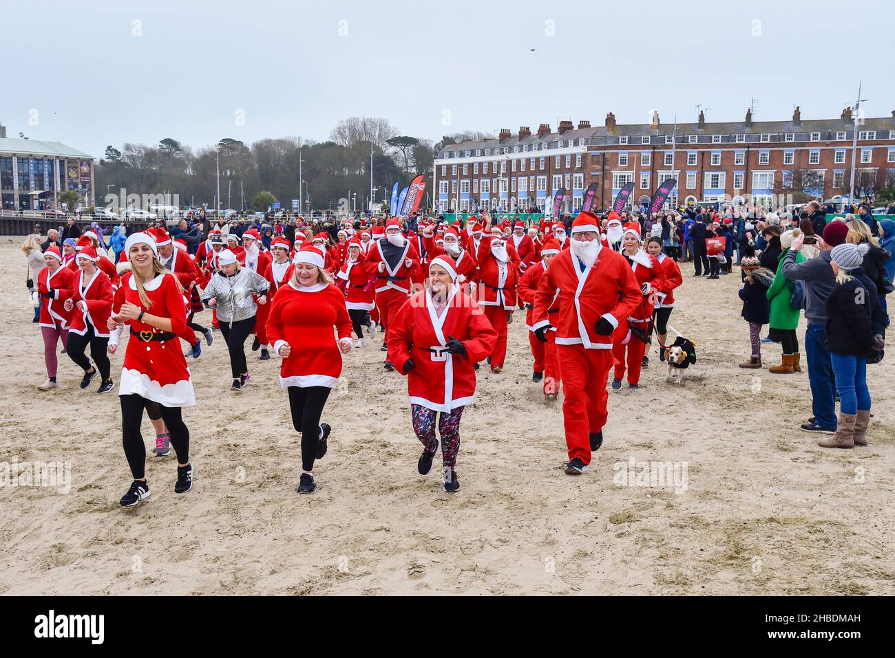 Weymouth, Dorset, Royaume-Uni.19th décembre 2021.Des centaines de coureurs vêtus de Santa prennent part à la course annuelle de pré-chistmas de Chase le Pudding sur la plage de Weymouth à Dorset.L'événement annuel est de recueillir de l'argent pour l'organisme de bienfaisance will Mackaness Trust.La chasse commence.Crédit photo : Graham Hunt/Alamy Live News Banque D'Images