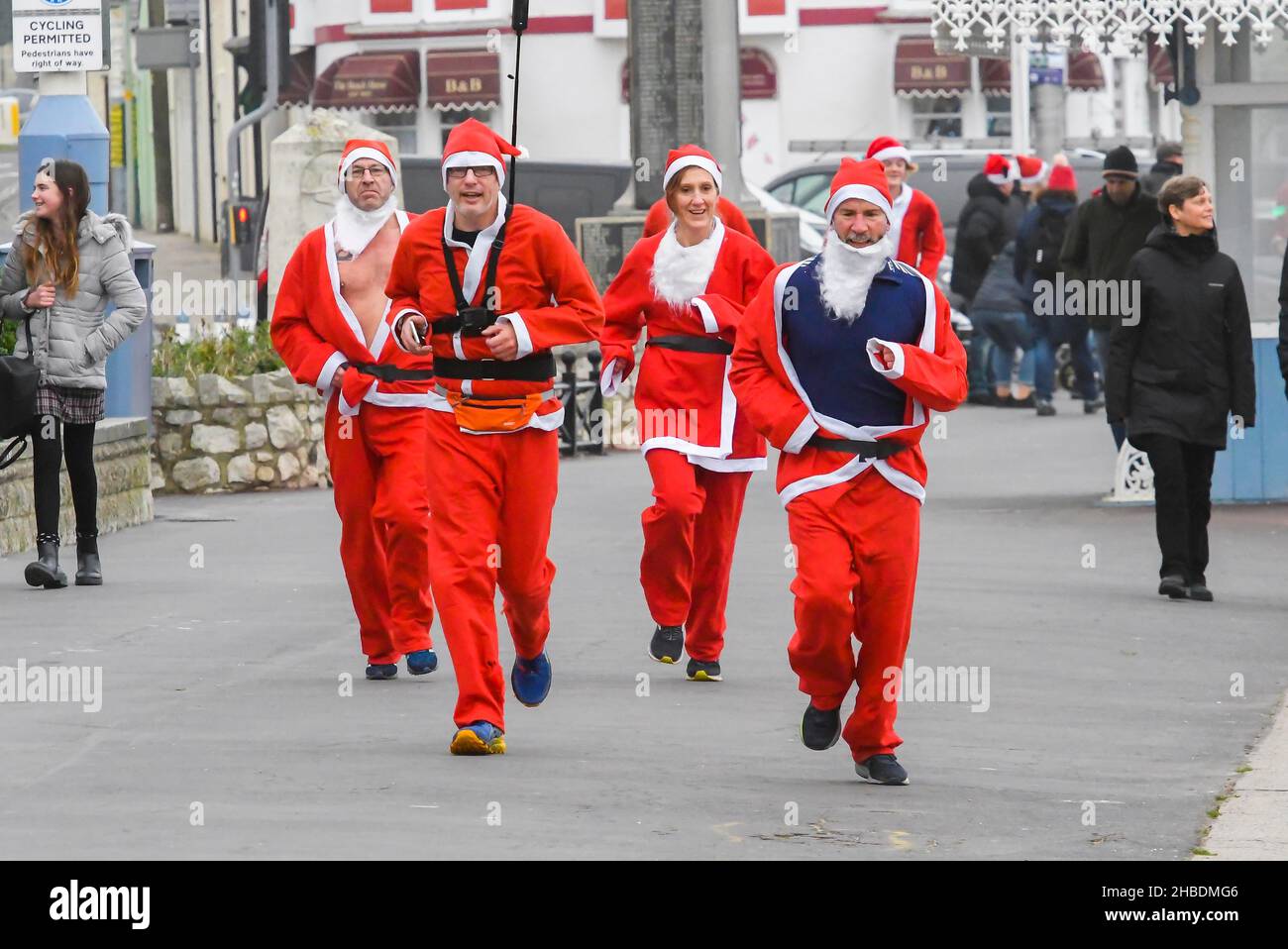 Weymouth, Dorset, Royaume-Uni.19th décembre 2021.Des centaines de coureurs vêtus de Santa prennent part à la course annuelle de pré-chistmas de Chase le Pudding sur la plage de Weymouth à Dorset.L'événement annuel est de recueillir de l'argent pour l'organisme de bienfaisance will Mackaness Trust.Chemin de table sur l'Esplanade pour la ligne d'arrivée.Crédit photo : Graham Hunt/Alamy Live News Banque D'Images