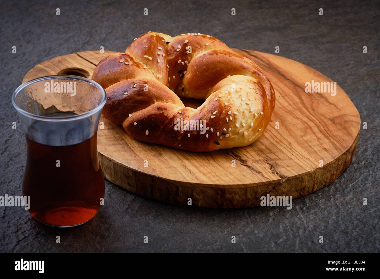 Pâtisserie turque acma et thé en verre traditionnel sur bois sur fond sombre Banque D'Images