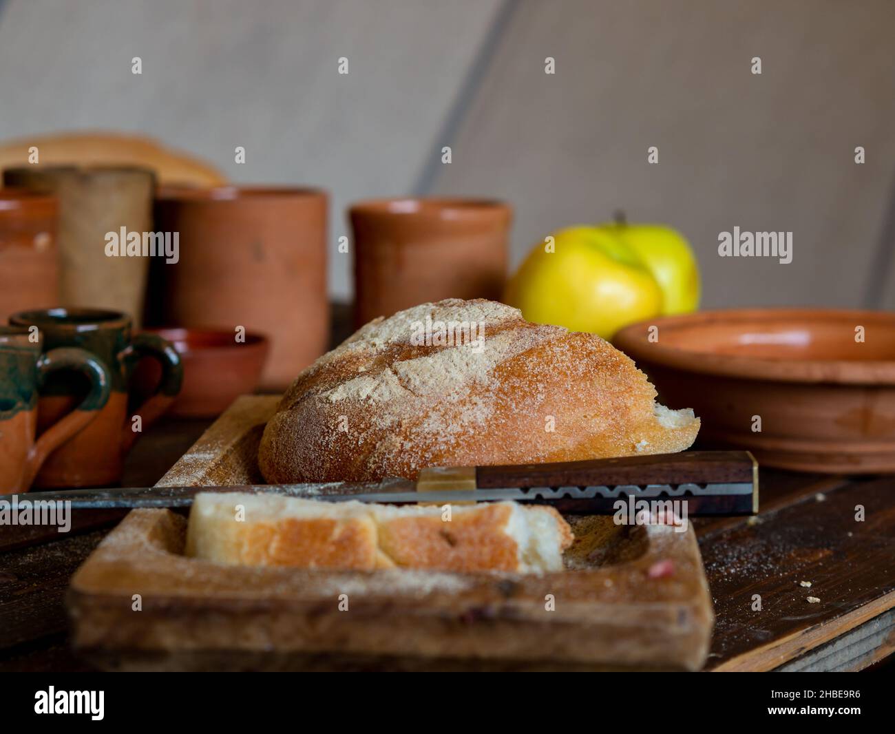 table médiévale avec pain et verres et cruches faites à la main en céramique Banque D'Images