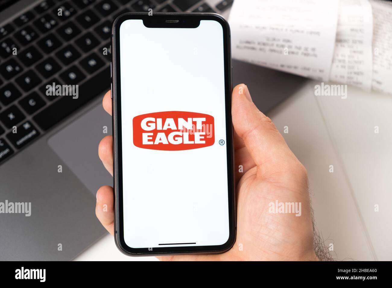 Application Giant Eagle d'un supermarché et d'une épicerie dans un smartphone.Un homme tient un smartphone avec une application pour faire du shopping et un ordinateur portable en arrière-plan.Novembre 2021, San Francisco, États-Unis Banque D'Images