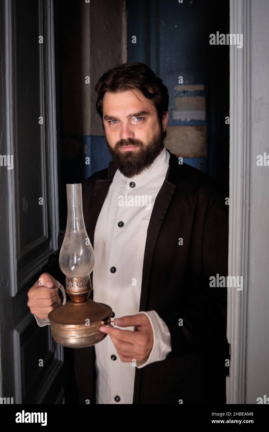 Portrait d'un homme à l'ancienne tenant une lampe Banque D'Images
