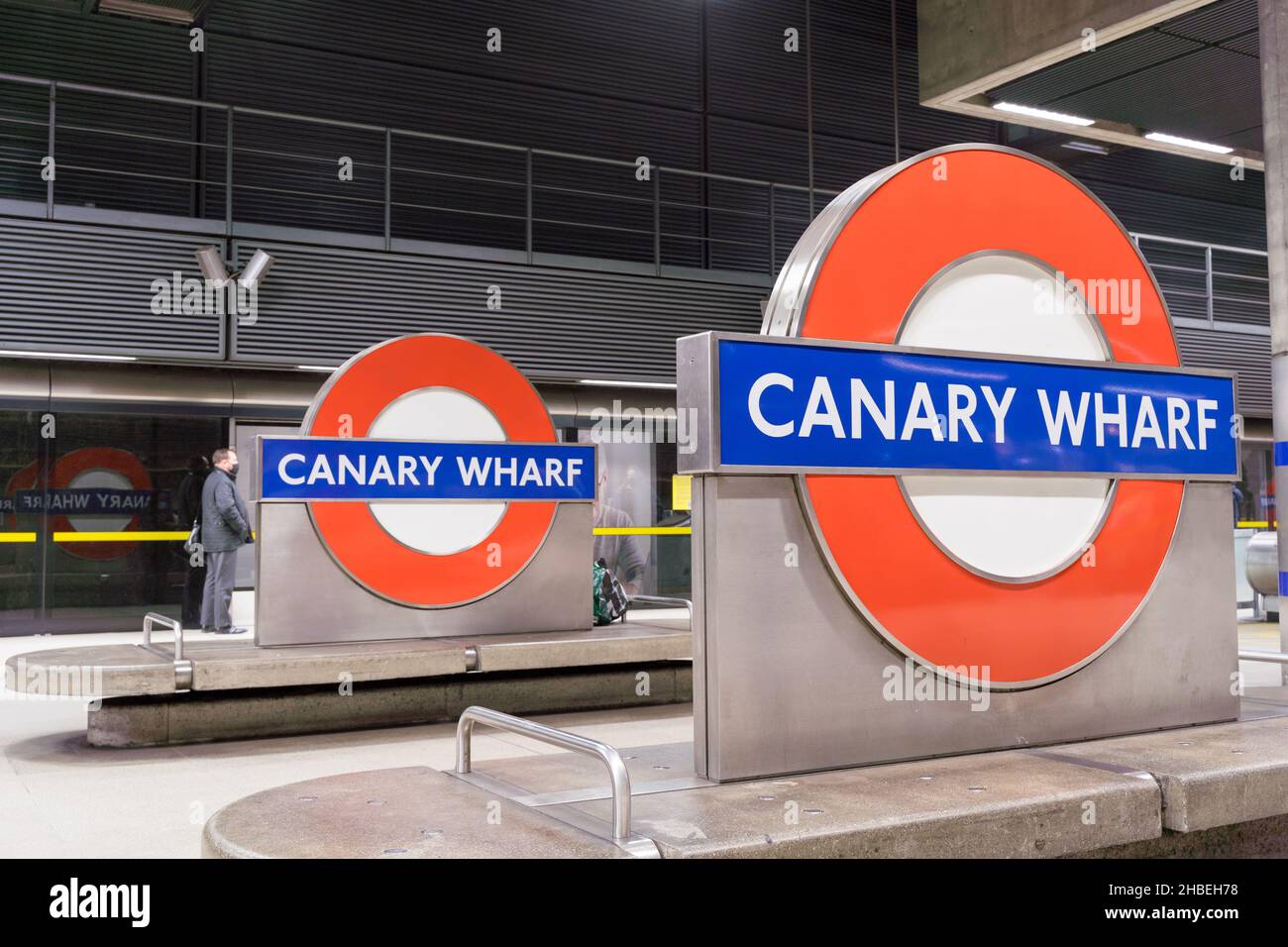 Un homme se trouve sur le bord de la plate-forme, attendant son train à la station de métro Canary Wharf London, Angleterre, Royaume-Uni Banque D'Images