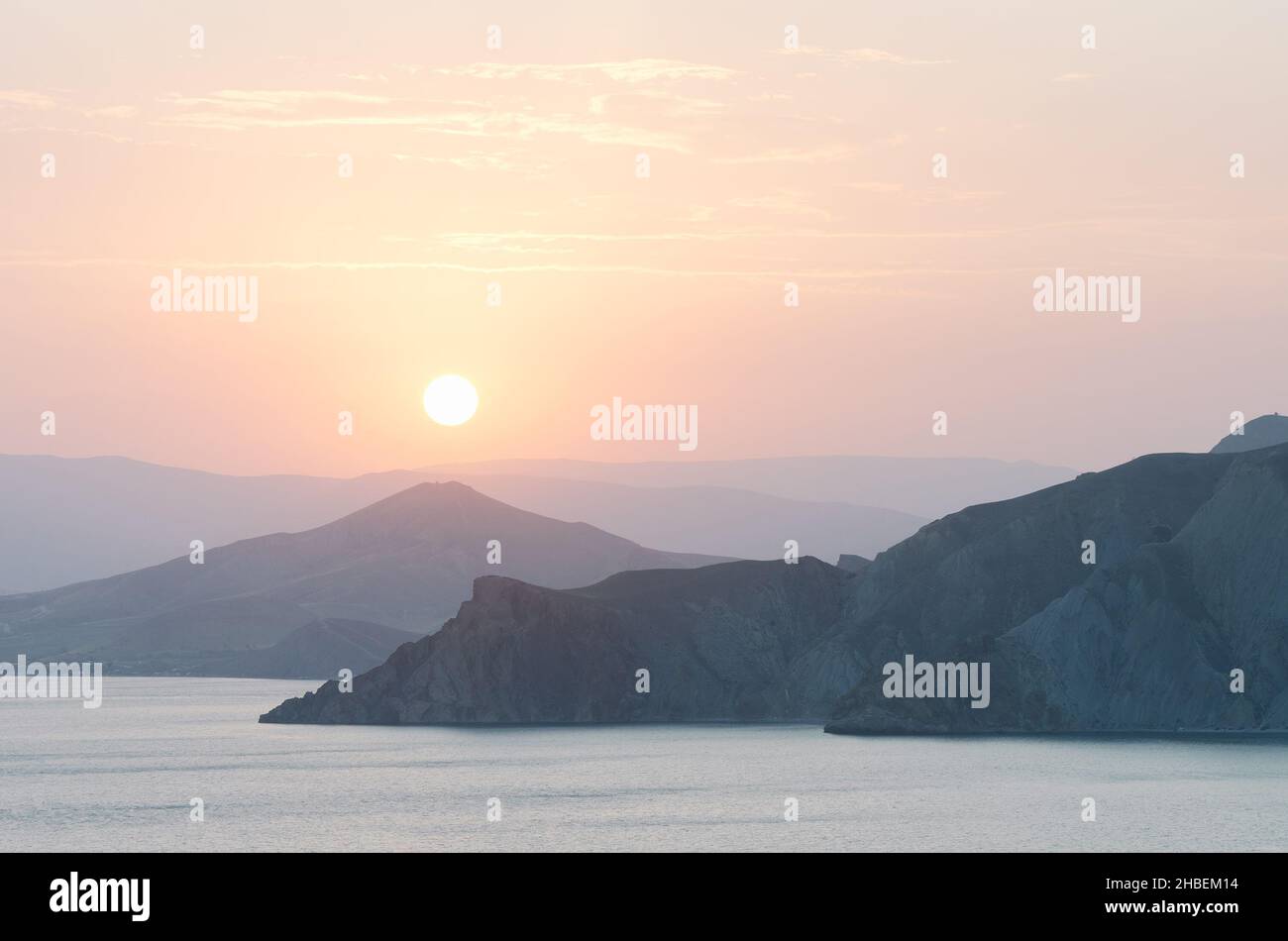 Vue sur la mer et les montagnes.Soirée d'été au bord de la mer.Coucher de soleil dans des tons pastel doux.Arrière-plan naturel pour le placement du texte Banque D'Images
