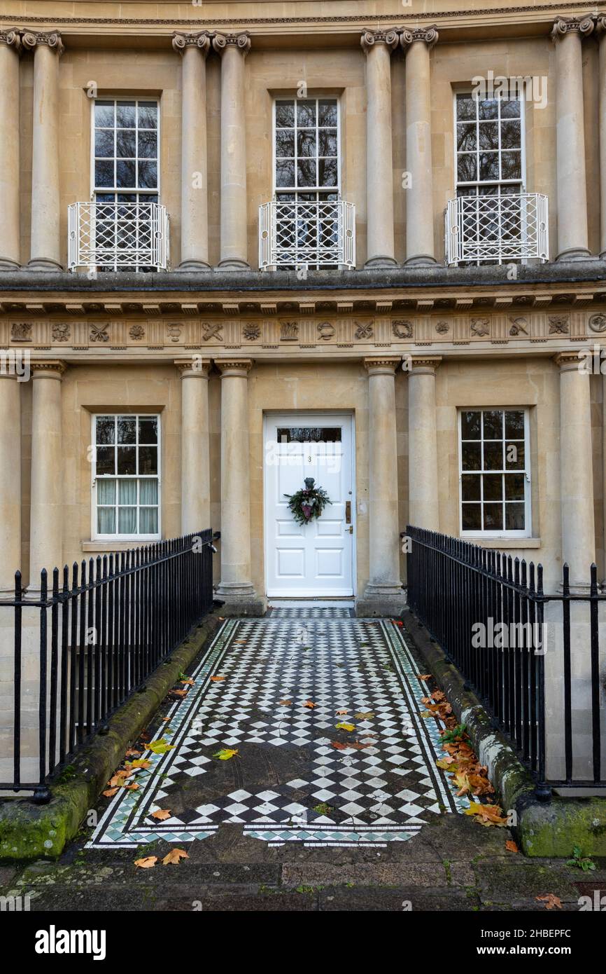 Porte d'entrée blanche et fenêtres d'une maison de ville géorgienne dans le Circus, ville de Bath, Angleterre.Un site classé au patrimoine mondial de l'UNESCO.Chemin carrelé orné.Noël. Banque D'Images
