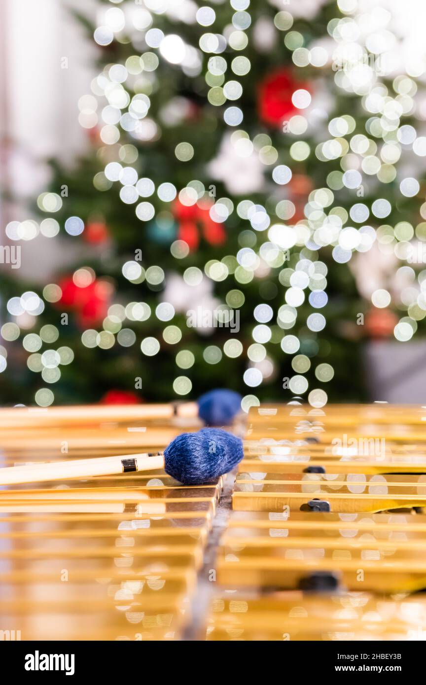 Bâtons de vibraphone reposant sur cet instrument à percussion.En arrière-plan, les lumières floues et floues de l'arbre de Noël. Banque D'Images
