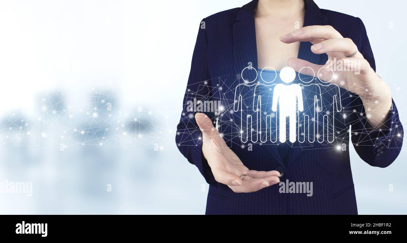 Communauté, unité, personnes et concept de soutien.Deux mains tenant Virtual holographic Human, icône leader avec un arrière-plan flou clair.Ressources humaines a Banque D'Images