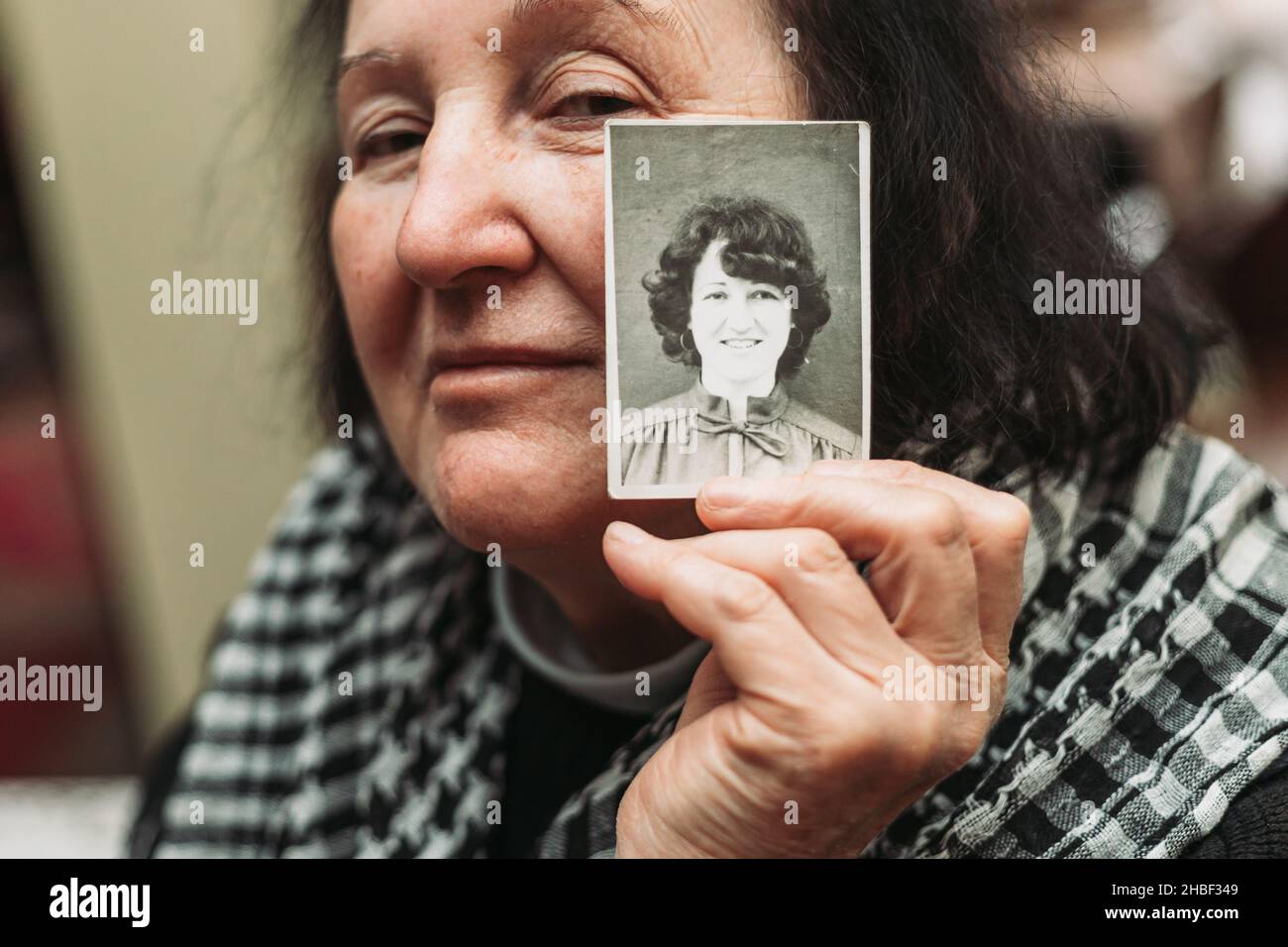 Femme âgée tenant une photo en noir et blanc de son jeune soi.Concept de passage du temps Banque D'Images