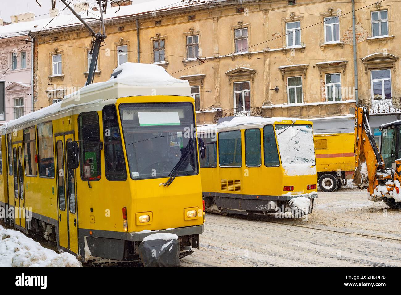 Tramway jaune, chasse-neige dans la neige s'effondre dans la rue de Lviv, ukraine Banque D'Images