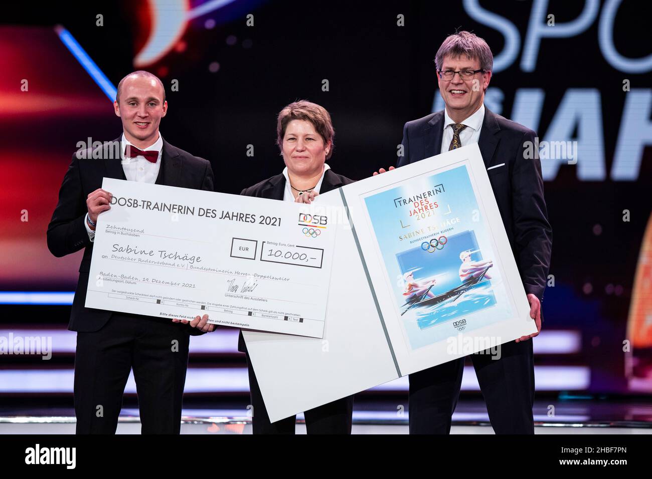 Baden Baden, Allemagne.19th décembre 2021.Sabine Tschäge (M) est sur scène avec Thomas Weikert (r), Président de la Confédération allemande des sports olympiques (DOSB), et le rameur Jonathan Rommelmann (l) lors de la cérémonie du "Trainer de l'année" à l'occasion de la cérémonie du "sportif de l'année 2021".Crédit : Tom Weller/dpa-Pool/dpa/Alay Live News Banque D'Images