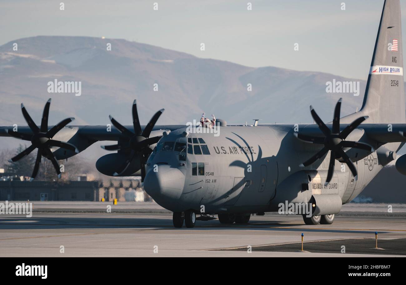 Le Père Noël débarque à l'extérieur d'un avion C-130 Hercules alors qu'il arrive à la base de la Garde nationale aérienne du Nevada, Reno, Nevada, le 18 décembre 2021.M. Claus et deux de ses elfes ont fait un tour de l'aile du 152nd Airlift à Reno pour l'aider à répandre la joie des fêtes aux Guardmen du Nevada et à leurs familles.(É.-U.Photo de la Garde nationale aérienne par Airman First Class Thomas Cox) Banque D'Images