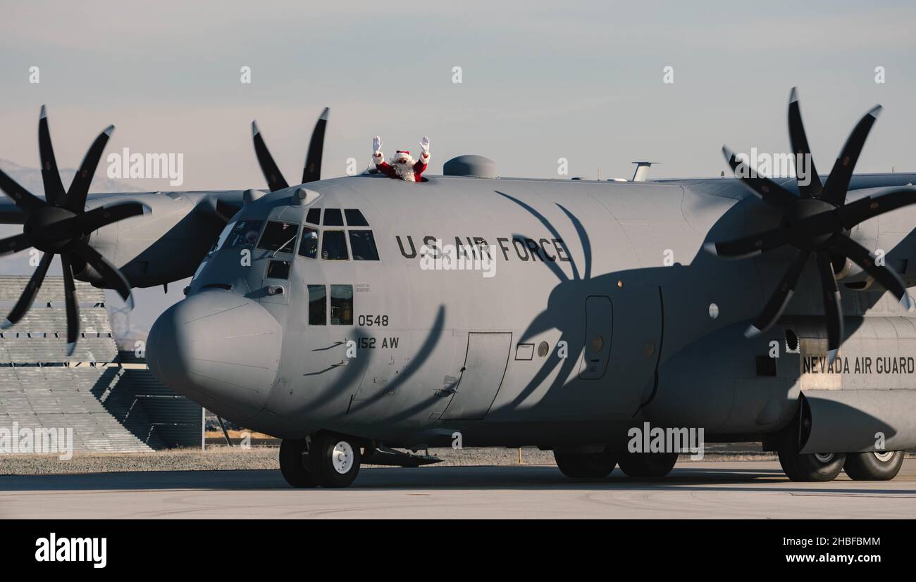 Le Père Noël débarque à l'extérieur d'un avion C-130 Hercules alors qu'il arrive à la base de la Garde nationale aérienne du Nevada, Reno, Nevada, le 18 décembre 2021.M. Claus et deux de ses elfes ont fait un tour de l'aile du 152nd Airlift à Reno pour l'aider à répandre la joie des fêtes aux Guardmen du Nevada et à leurs familles.(É.-U.Photo de la Garde nationale aérienne par Airman First Class Thomas Cox) Banque D'Images
