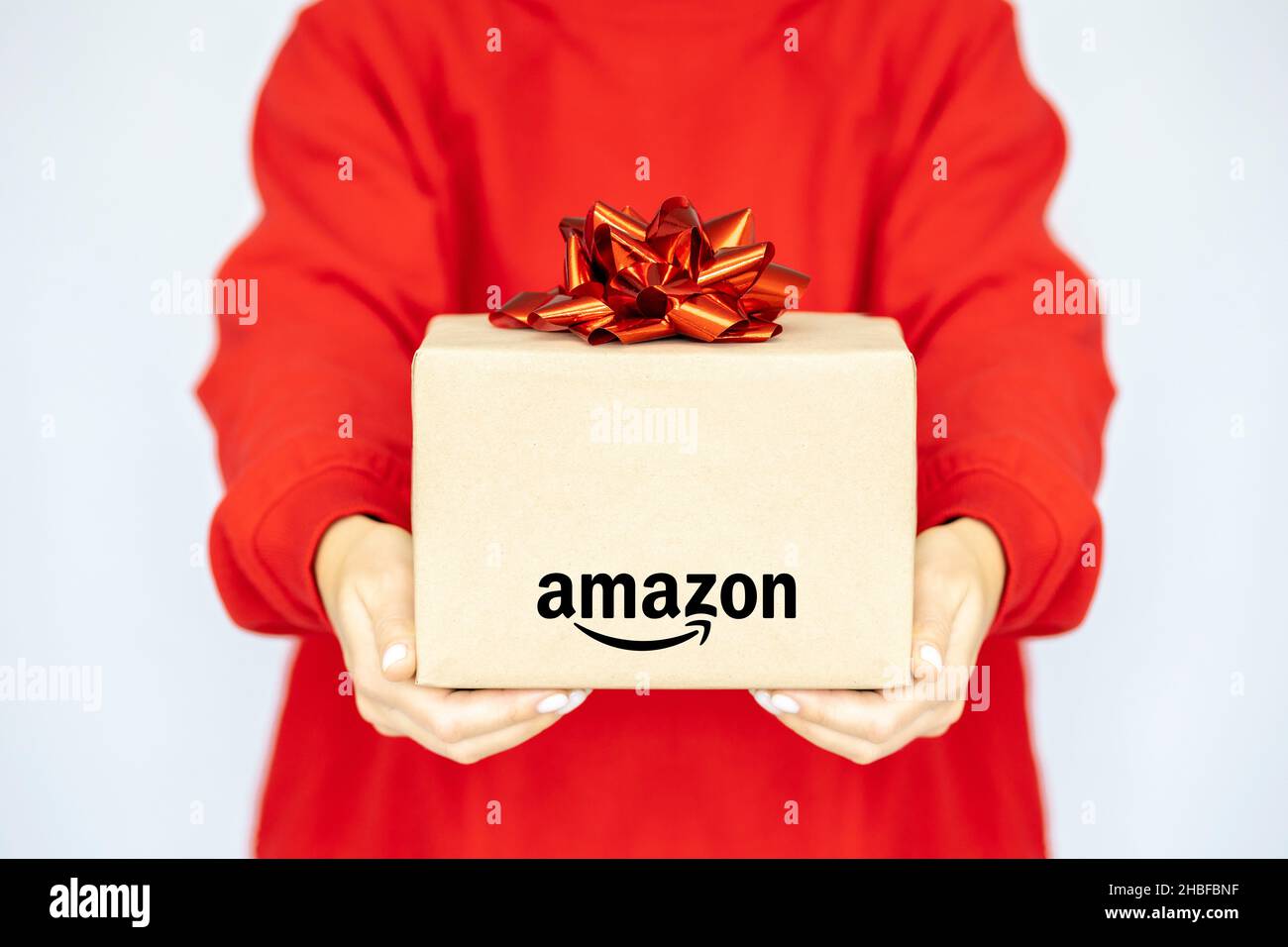 Livraison express Amazon.Une jeune femme en sweat-shirt tient une boîte en  carton avec un noeud très peri.Vente d'achats en ligne Photo Stock - Alamy
